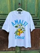 Remera blanca de corte amplio con estampado de limones, flores y texto en azul.