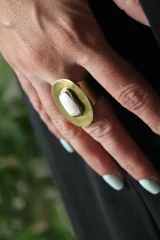 Anillo de bronce con base circular y piedra blanca central de forma ovalada. Diseño ajustable a presión.