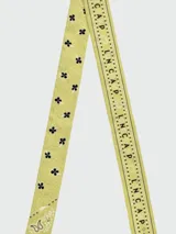 Pañuelo tipo bandana de seda, color amarillo con estampado gráfico y letras en negro. Diseño cuadrado con bordes definidos.