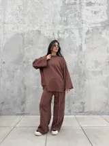 Pantalón de calce cómodo color marrón, con cintura elástica en contraste color crema, bolsillos laterales funcionales y diseño con recortes y costuras overlock a la vista.