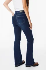 Jean de corte bootcut en color azul oscuro, con tiro alto y cierre frontal con botón metálico. Presenta un diseño clásico de cinco bolsillos con costuras en contraste.