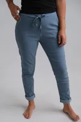 Pantalón de corte recto y ajuste cómodo, confeccionado en tela elástica color celeste. Presenta cintura elástica con cordón ajustable, bolsillos laterales y ruedos doblados.