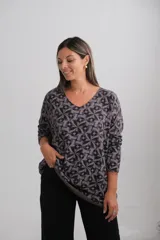 Sweater de punto con estampado geométrico de mosaicos en tonos gris y negro, de corte amplio, escote en V y manga larga.