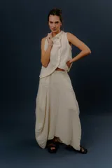 Pollera larga de lino color gris topo, de diseño amplio con volumen, cintura elástica y bolsillos delanteros.