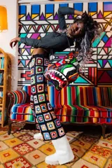 Mochila Sprayground con estampado a cuadros en tonos grises y diseño de boca de tiburón con detalles multicolores.