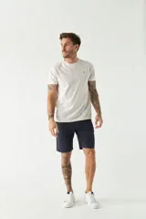 Bermuda tipo china de corte clásico, con bolsillos laterales y traseros, cierre frontal y pasacintos. Presenta un diseño liso y minimalista con logo bordado.