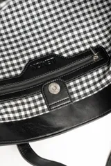 Bolso tipo tote bag color marrón, confeccionado en cuero sintético, con doble asa superior y detalle de placa metálica dorada con logo en la parte frontal.
