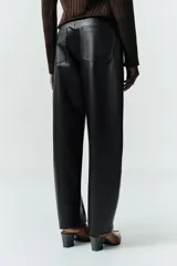 Pantalón de tiro medio con diseño tipo ballon, confeccionado en material efecto piel. Cuenta con cinco bolsillos, cierre frontal con cremallera y botón metálico.