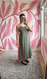 Vestido largo verde oliva con breteles finos y corte evasé. Presenta un panel lateral en color rosa.