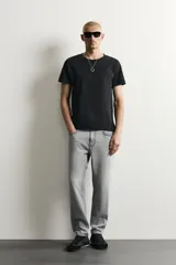 Jeans de corte slim cropped confeccionados en denim de algodón rígido con efecto lavado. Presentan tiro medio, cierre frontal con cremallera y botón, y diseño clásico de cinco bolsillos.