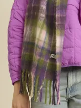 Bufanda de tejido suave con diseño a cuadros en tonos beige y amarillo neón. Presenta flecos en los extremos y una etiqueta de la marca Rusty.