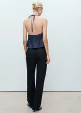 Pantalón sastrero negro de tiro bajo, con pinzas en la parte delantera, bolsillos de ribete en la parte posterior y diseño recto de largo completo.