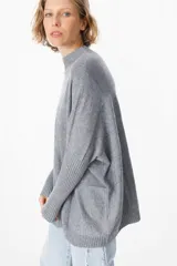 Sweater crudo de punto con cuello alto y mangas largas con puños ajustados.