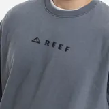 Buzo de cuello redondo Reef, color gris con efecto lavado, de corte holgado y mangas largas con puños acanalados. Presenta un pequeño logo bordado en el pecho.