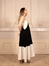 Vestido largo sin mangas, con escote en V y diseño de bloques de color. La parte superior es blanca, la sección media es color camel/marrón claro, y el ruedo inferior es blanco.