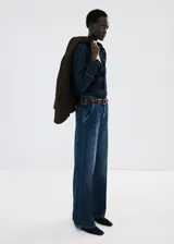Jeans de denim azul de corte wide leg, tiro medio y diseño clásico de cinco bolsillos con cierre frontal de botón y cremallera.