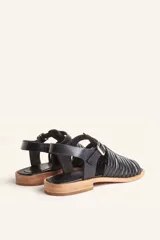 Sandalia plateada de cuero con tiras entretejidas, hebilla lateral y taco bajo.