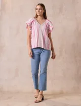 Blusa Cupio de lino estampado a rayas rosas y blancas, con escote en V y aplique de crochet en el frente. Tiene mangas cortas amplias.