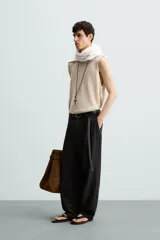 Camiseta tipo tank (sin mangas) de punto, color beige claro, con cuello redondo amplio y corte relajado.