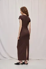 Vestido largo marrón de corte ajustado, con cuello redondo, mangas cortas y detalle drapeado en la cintura con hebilla metálica dorada.