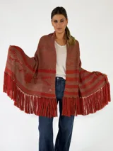 Pashmina de tejido abierto color tostado con detalles rayados y bordados florales en tono terracota, terminada con largos flecos en los bordes.