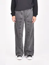 Pantalon de jean con efecto lavado, corte recto y holgado, con costuras verticales decorativas en el frente y bolsillos laterales.