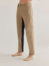 Pantalón cigarette color beige, de denim con costuras visibles, pretina trasera elástica y bolsillos delanteros y traseros.