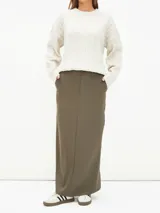 Falda midi negra de corte recto, con cintura alta, bolsillos laterales y cierre frontal con botón.