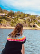 Sweater de punto grueso color negro con diseño geométrico multicolor en el pecho y cuello. Tejido a mano.