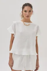 Blusa blanca de lino de manga corta, con volados en las mangas y espalda cruzada adornada con volados.