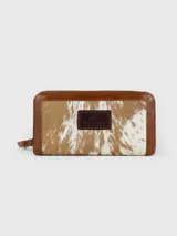 Billetera de cuero con detalles en pelo vacuno con patrón animal print, cierre perimetral y parche de cuero con logo grabado en el frente.