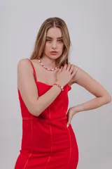 Vestido corto rojo de tirantes con diseño ajustado y costuras visibles en contraste.