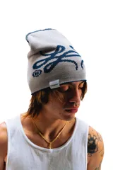 Gorro de lana tejido reversible, un lado azul marino y el otro gris, con diseño de moños en ambos lados.