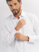 Camisa de manga larga color azul marino, confeccionada en algodón, con cuello abotonado y cierre frontal de botones.