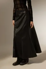 Falda larga de corte evasé confeccionada en cuero sintético negro, con costuras verticales que definen su estructura.