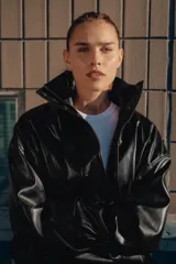 Chaqueta de efecto piel con cuello subido, manga larga con puños y bajo elástico. Presenta cierre frontal con cremallera y botones a presión ocultos, además de bolsillos laterales y forro interior.