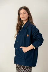 Campera de jean oversize en color azul oscuro, con corte recto, cuello camisero, cierre frontal con botones y bolsillos frontales tipo parche.