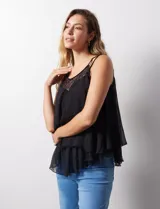 Blusa negra de gasa con breteles finos trenzados, escote redondo y capas superpuestas de encaje y gasa en el frente.