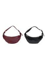 Cartera negra en forma de media luna, con cierre superior y ojales metálicos plateados en el borde.