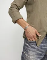 Pulsera de cuero trenzado color marrón con cierre de mosquetón entrelazado bañado en plata.