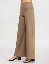 Pantalón de tiro alto con corte wide leg, confeccionado en tejido elastizado. Presenta una costura vertical decorativa en el frente de cada pierna y un diseño de calce cómodo.