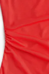 Vestido corto rojo de malla, ajustado al cuerpo, con escote drapeado tipo cowl neck y breteles finos. Presenta frunces laterales que crean un efecto drapeado en la falda.