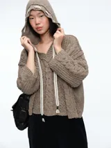 Buzo de tejido de punto con diseño de ochos, capucha integrada con cordones ajustables en contraste, manga larga y corte holgado.