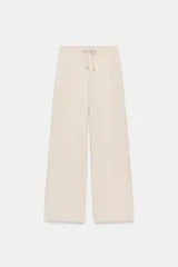Pantalón de tiro medio confeccionado en tejido de punto elástico con pierna recta. Cuenta con cintura elástica ajustable mediante cordones y bolsillos laterales.