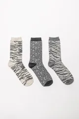 Pack de tres pares de medias de media caña con estampados animal print variados en tonos grises, blanco y negro.