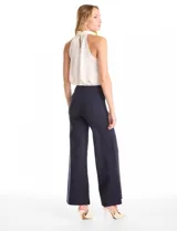 Pantalón palazzo de tiro alto con corte amplio y costuras verticales frontales que estilizan la silueta. Presenta una cintura lisa y estructura fluida.