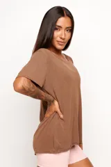 Remera de corte holgado y diseño minimalista, confeccionada en una mezcla de viscosa, lino y elastano. Presenta cuello redondo amplio y mangas cortas con terminación al corte.