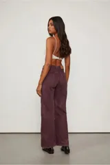 Pantalón de tiro medio color borgoña, con dos parches delanteros que simulan ser bolsillos y costuras visibles.