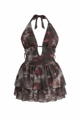 Vestido corto con short incorporado, diseño halter con escote profundo y falda con volados en capas. Presenta un estampado abstracto en tonos oscuros.