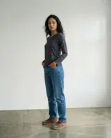 Remera de manga larga en jersey con estampado de líneas orgánicas en tonos verdes, violetas y naranjas. Presenta un corte recto y cuello redondo, diseñada para un ajuste cómodo y versátil.